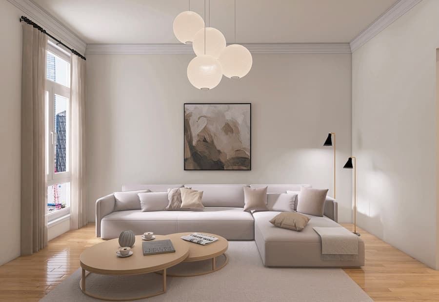 A bright living room with layered lighting, a sectional sofa and spherical pendant lamps